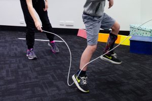 Young child skipping with physiotherapist
