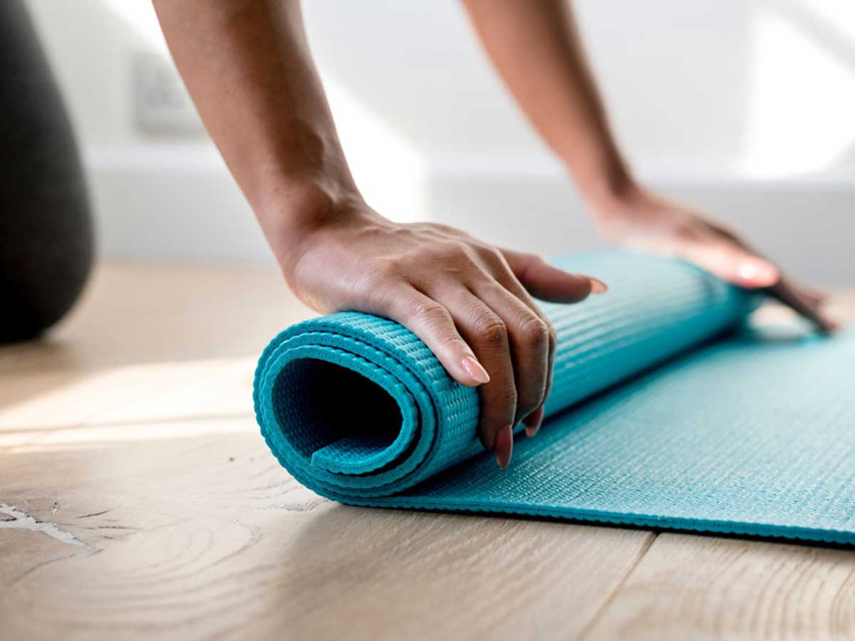 Lady rolling up exercise mat